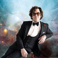 freddy fischer, mann im smoking vor kosmischem hintergrund