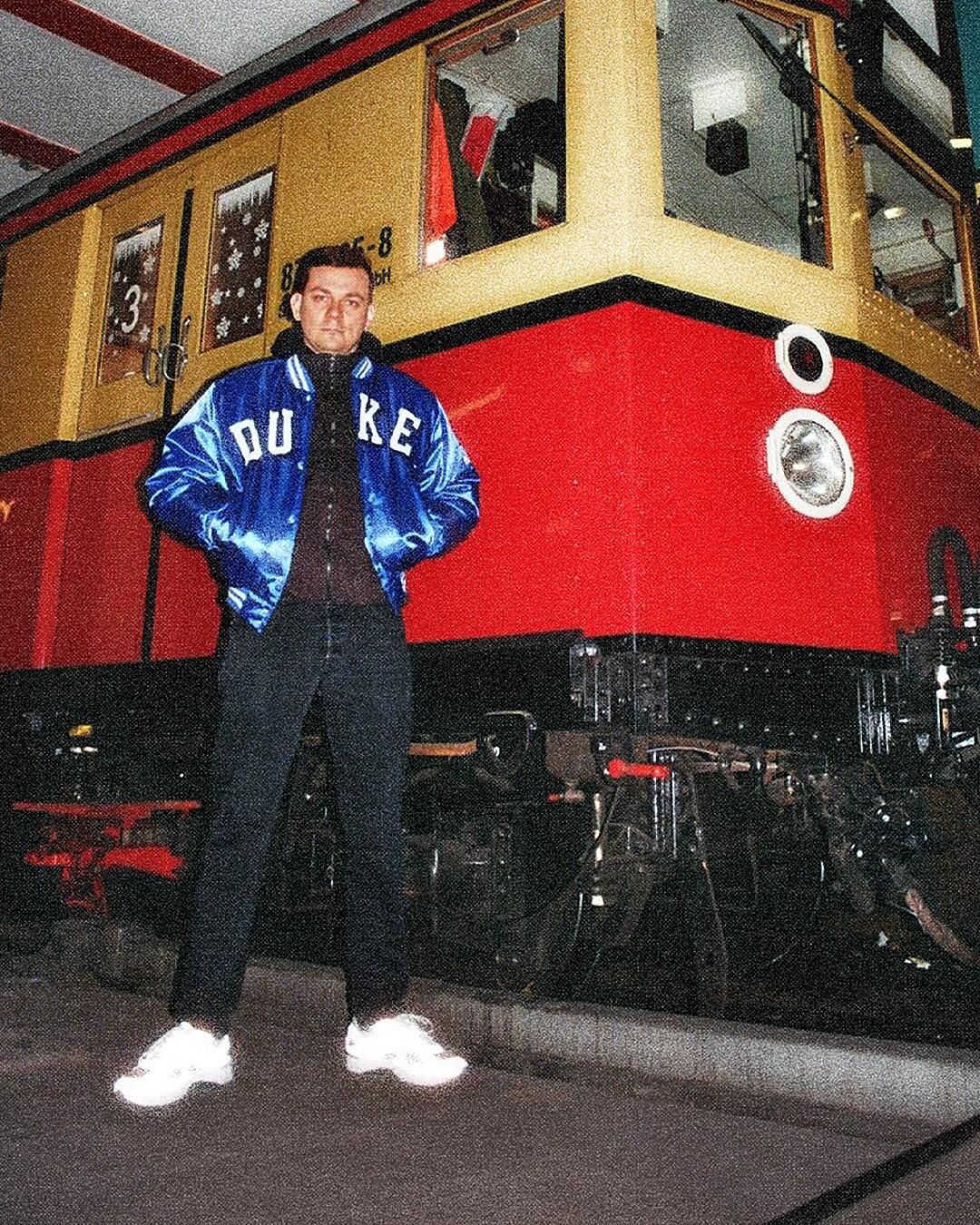 shacke one vor roter straßenbahn in blauer jacke