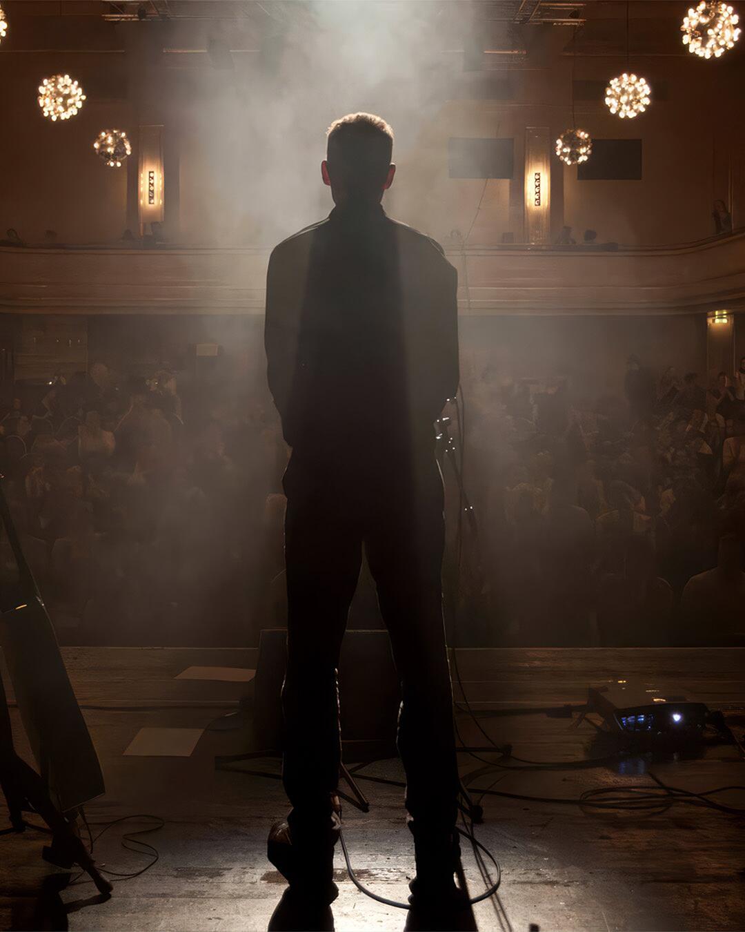 tex, silhouettenportrait auf bühne vor publikum