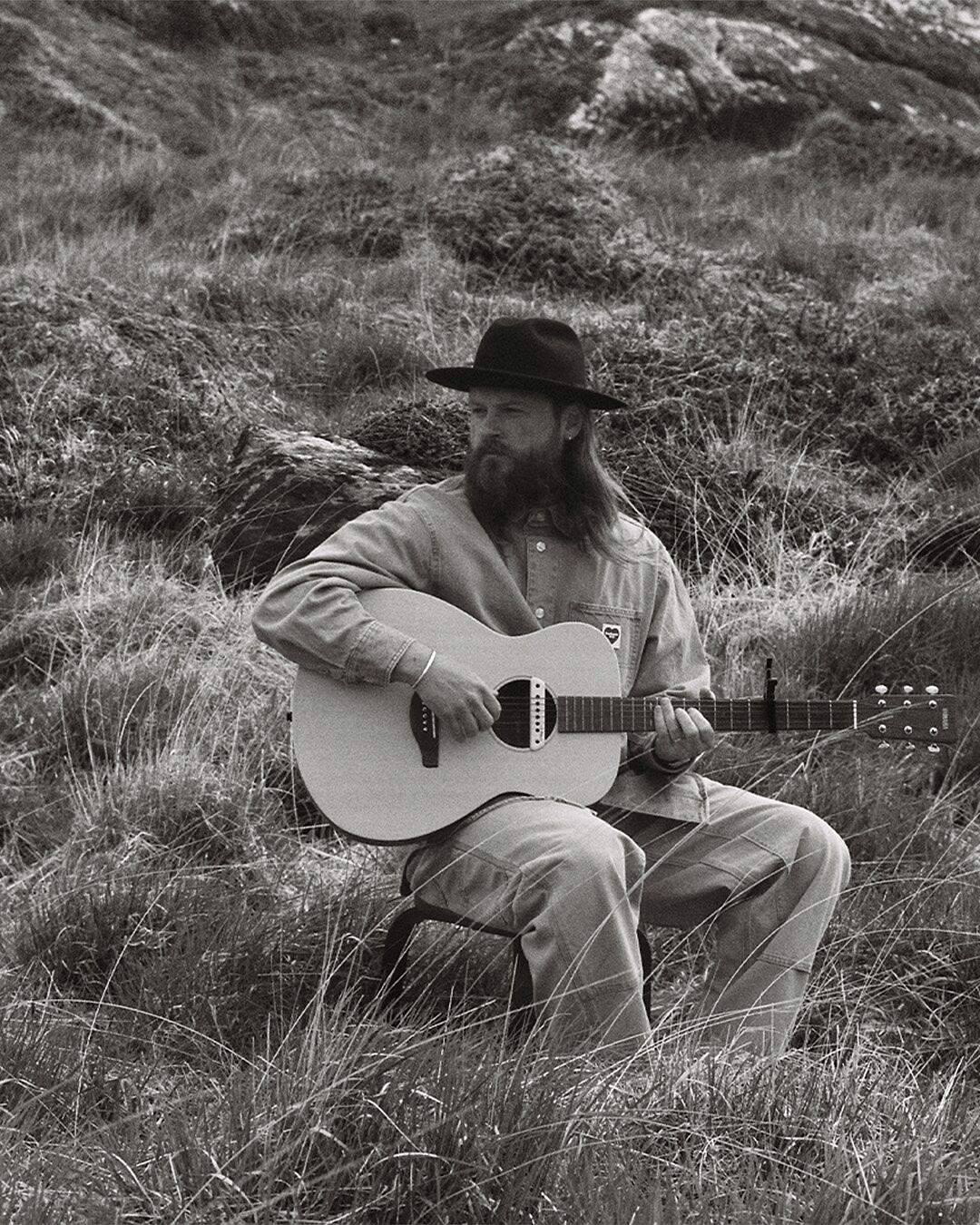 ian hooper, mann mit gitarre in landschaft in schwarz-weiß