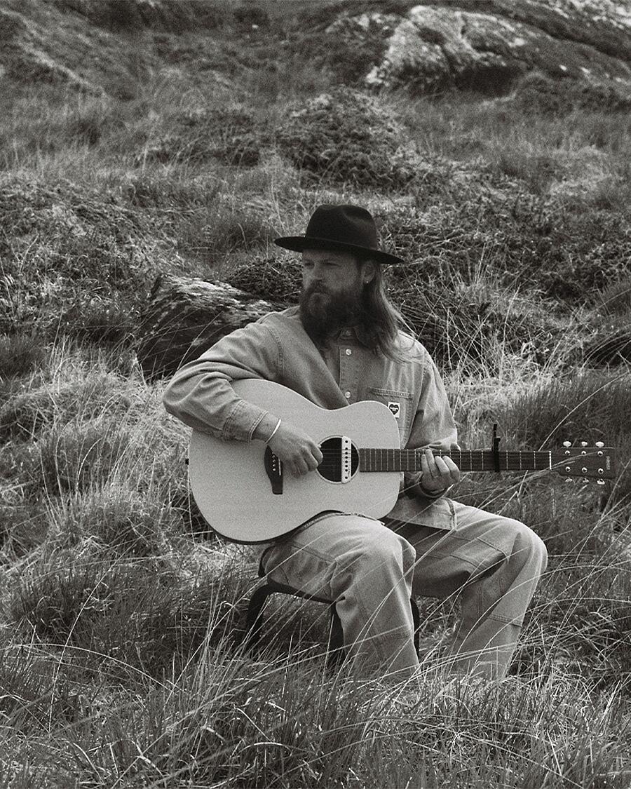 ian hooper, mann mit gitarre in landschaft in schwarz-weiß