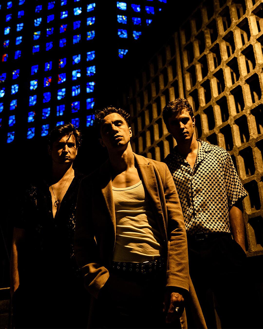 tulpe, dreiköpfige band bei nacht vor betonwand