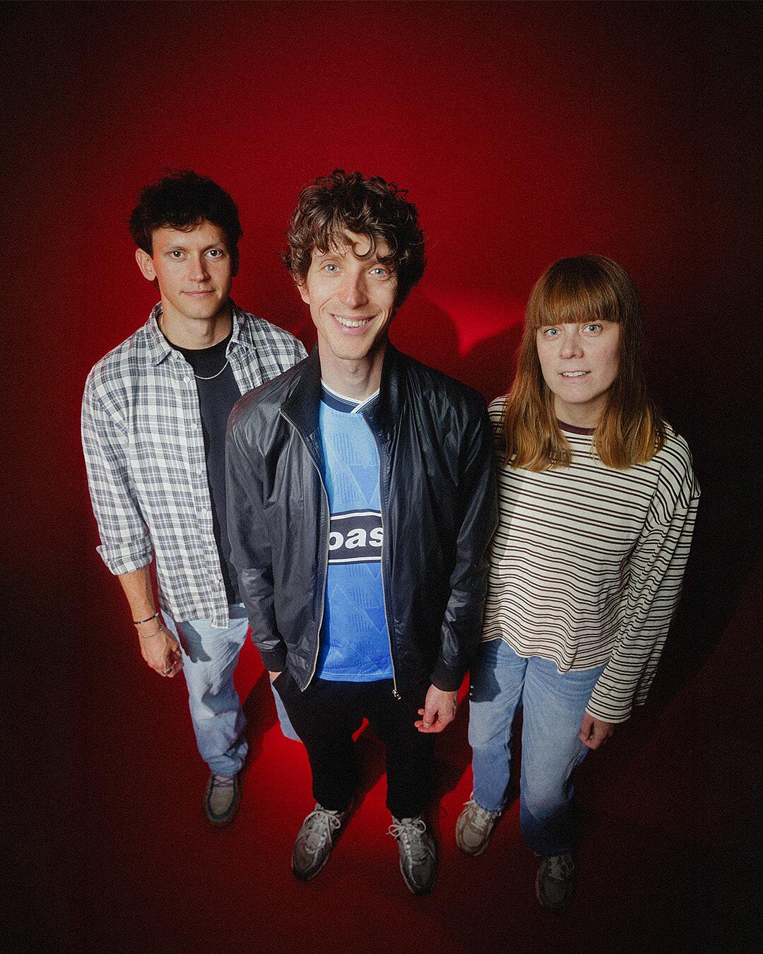 tonbandgerät, dreiköpfige band vor rot beleuchtetem hintergrund