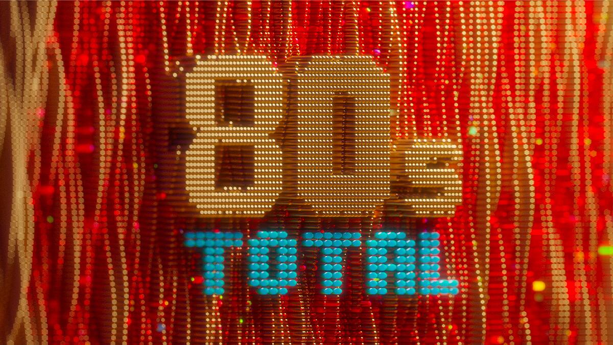 80s total, leuchtender schriftzug vor rotem hintergrund