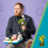 julius fischer, portrait mit mikrofon und blumenstrauß
