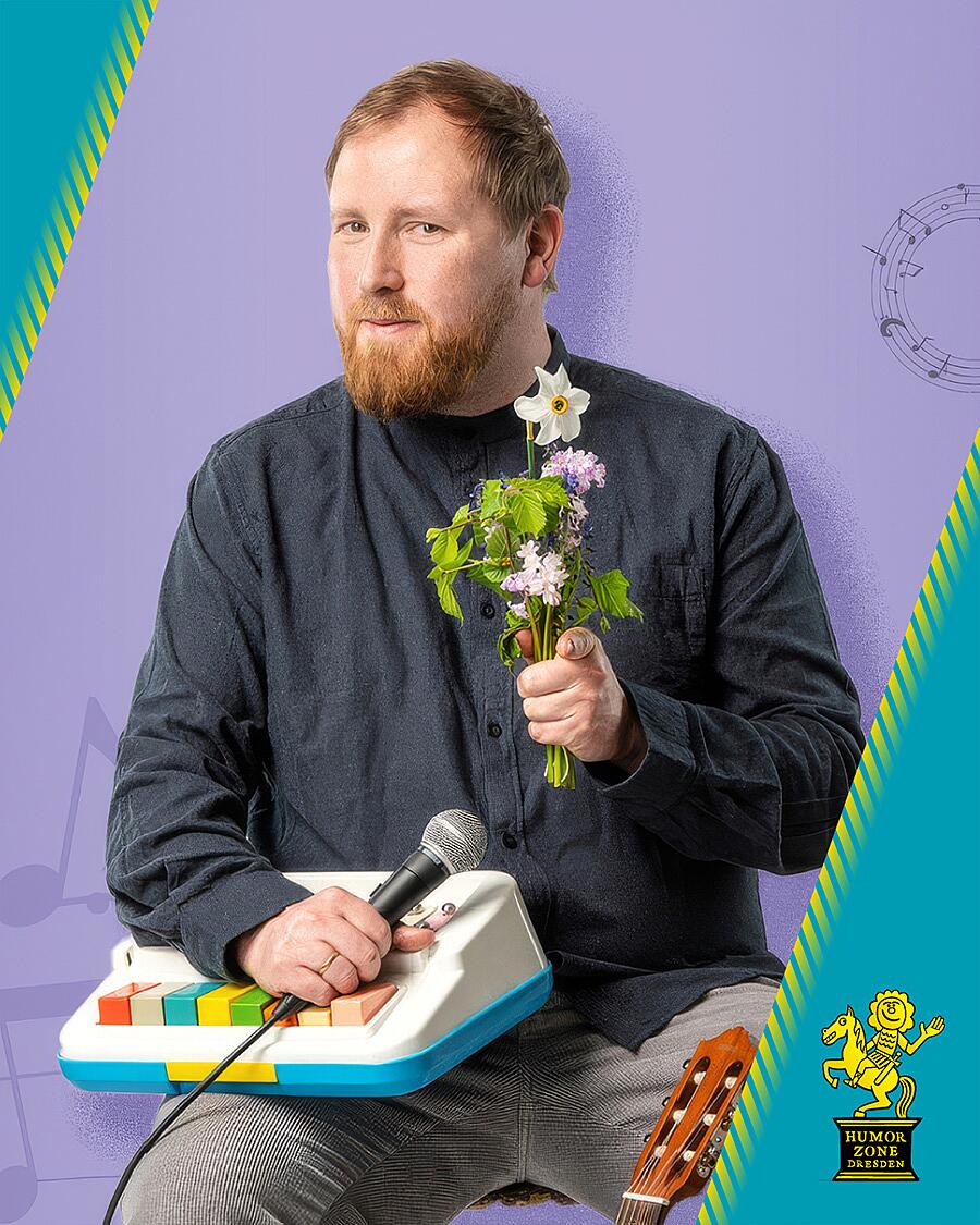 julius fischer, portrait mit mikrofon und blumenstrauß
