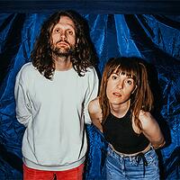 ell, duo vor blauem hintergrund mit direktem blick in kamera