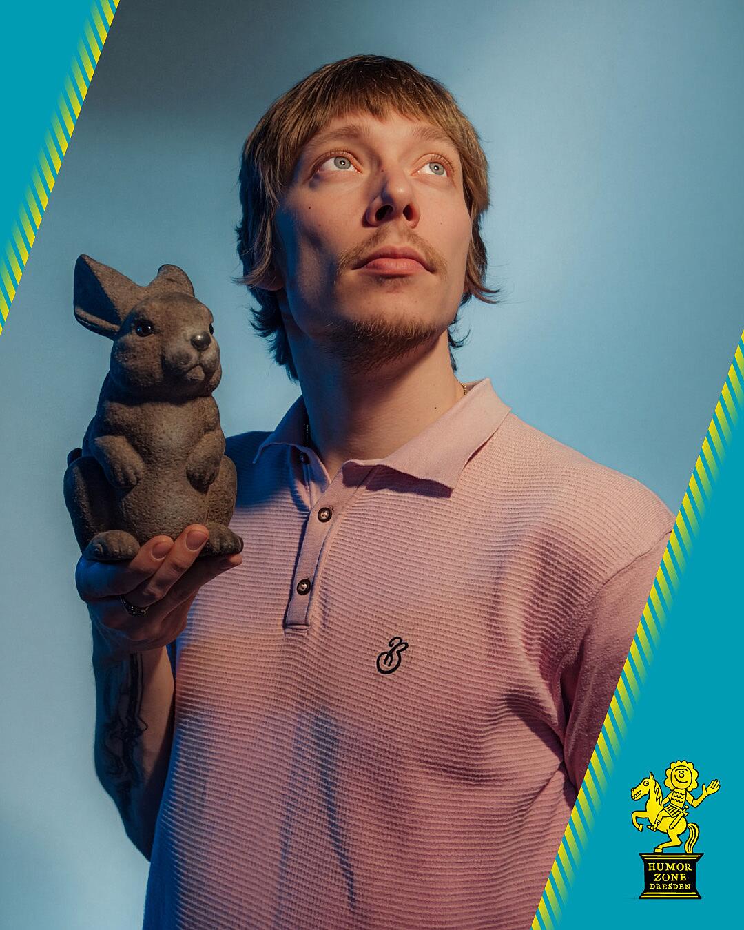 robert alan, portrait mit tierfigur vor blauem hintergrund